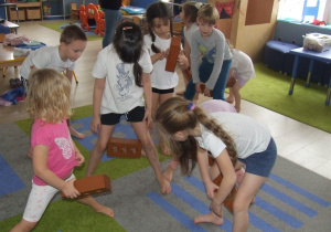 Dzieci ćwiczą z cegiełkami.
