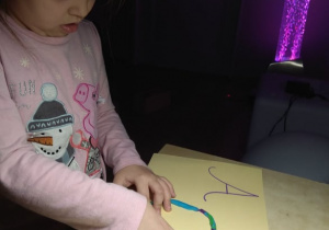 Dziewczynka wykleja plasteliną litery.