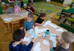 Dzieci projektują skarpety - malują wzory na sylwetach.