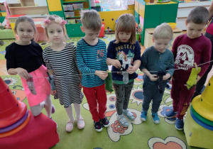 Dzieci wieszają na sznurku wyprane skarpety.