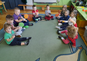 Dzieci grają na zrobionych przez siebie instrumentach.