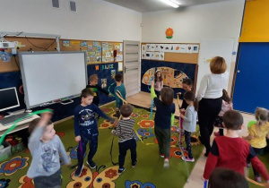 Dzieci słuchając utworu tańczą z bibułą w odpowiednim kolorze.