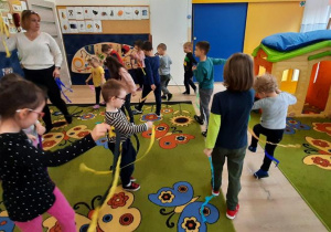 Dzieci słuchając utworu tańczą z bibułą w odpowiednim kolorze.