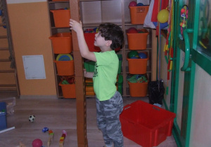 Chłopiec buduje wieżę z klocków.