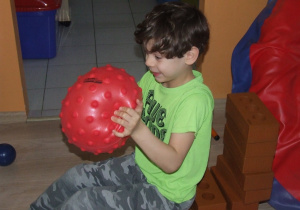 Chłopiec zgniata piłkę.