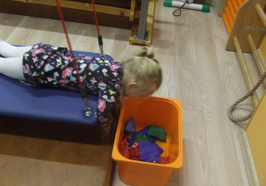 Dziewczynka ćwiczy z woreczkami na podwieszeniu.