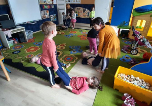 Dzieci przeciągają kolegę po podłodze.