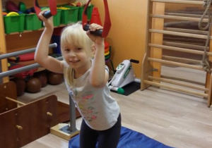 Dziewczynka ćwiczy na dysku równoważnym u użyciem systemu Neurac.